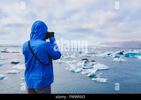 nature travel photographer, person taking photo of arctic icebergs in Iceland Stock Photo