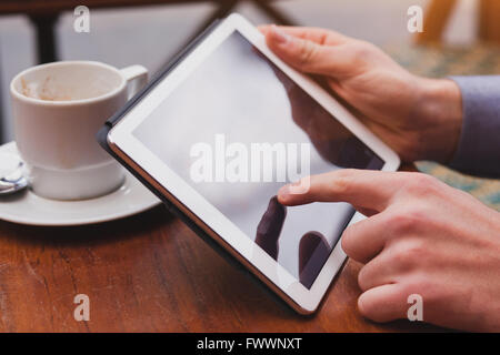 using internet on tablet in cafe, checking email and social networks on touchpad, closeup of finger Stock Photo