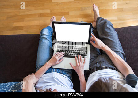 young couple using internet on laptop with empty blank screen at home, top view, buy or rent online concept Stock Photo