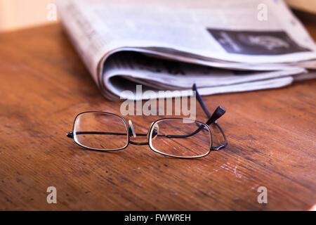 reading newspapers, glasses and daily news on wooden table Stock Photo