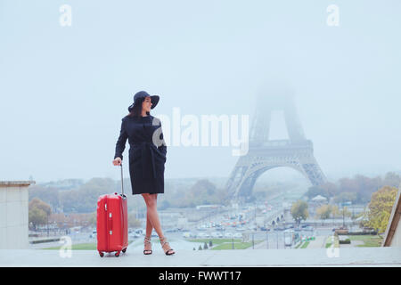 tourist in Paris, Europe tour, woman with luggage near Eiffel Tower, France Stock Photo