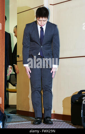 Japanese badminton player Kenichi Tago bows in deep apology at the beginning of a news conference on April 8, 2016, Tokyo, Japan. An NTT East badminton team representative, Masayuki Okumoto, said that Keinichi Tago had lost approximately 10 million yen through gambling and had visited an illegal casino 60 times. He also said that world number 2, Kento Momota had lost 500,000 yen. Gambling is illegal in Japan and can carry a prison sentence and both the badminton stars admitted visiting a yakuza operated casino. Momota and Tago were expected to represent Japan in the Rio Olympic Games with Momo Stock Photo