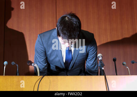 Japanese badminton player Kenichi Tago bows in deep apology during a news conference on April 8, 2016, Tokyo, Japan. An NTT East badminton team representative, Masayuki Okumoto, said that Keinichi Tago had lost approximately 10 million yen through gambling and had visited an illegal casino 60 times. He also said that world number 2, Kento Momota had lost 500,000 yen. Gambling is illegal in Japan and can carry a prison sentence and both the badminton stars admitted visiting a yakuza operated casino. Momota and Tago were expected to represent Japan in the Rio Olympic Games with Momota a medal fa Stock Photo