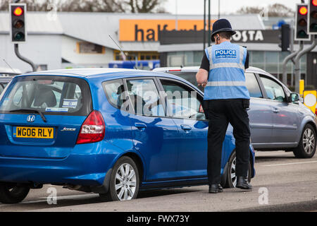 Crawley, UK. 8th April, 2016. A police liaison officer asks a member of the public shouting from a car at protesters outside the Thales arms factory in Crawley to close his window. Credit:  Mark Kerrison/Alamy Live News Stock Photo