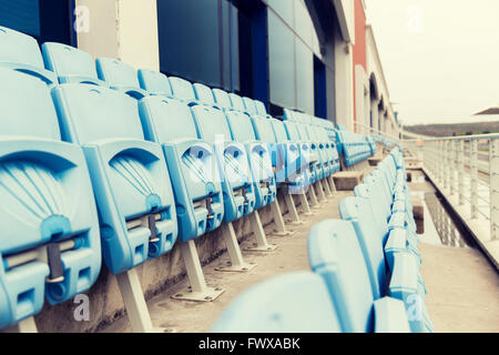 rows with folded seats of bleachers on stadium Stock Photo