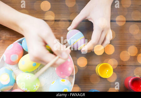 close up of woman hands coloring easter eggs Stock Photo