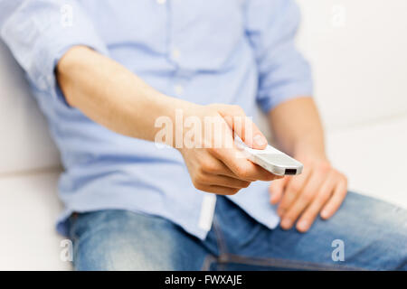 close up of man with tv remote control at home Stock Photo