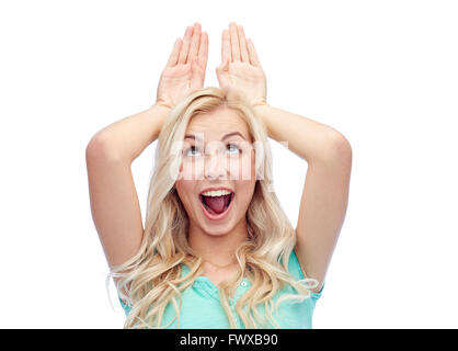 happy smiling young woman making bunny ears Stock Photo