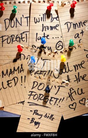 notes and messages pinned on a corkboard Stock Photo