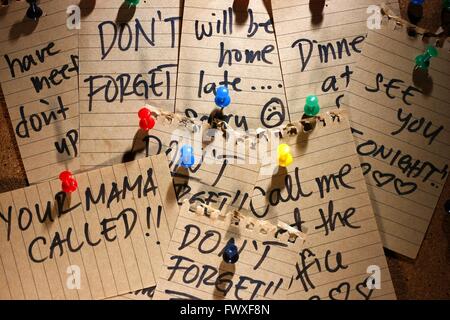 notes and messages pinned on a corkboard Stock Photo