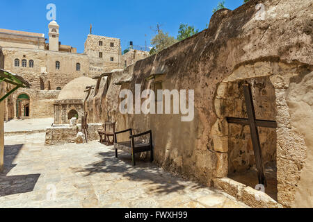 Wooden cross and stone monastic cells on the roof of the Church of the Holy Sepulchre in Jerusalem, Israel. Stock Photo