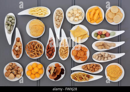 Large savory snack selection in porcelain dishes over gray wooden background. Stock Photo