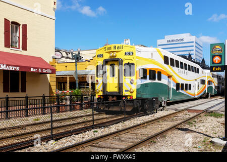 Sunrail train and engine travelling through Church Street station, Downtown Orlando, Florida, USA Stock Photo