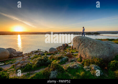 Man standing on the edge of the rock at sunset. View from Granite Island, South Australia Stock Photo