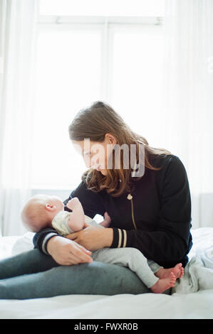 Sweden, Teenage girl (16-17) holding little baby sister (2-5 months)