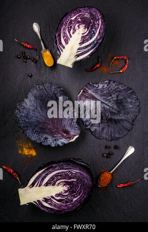 Slices of purple cabbage with red and orange spices on a black background Stock Photo