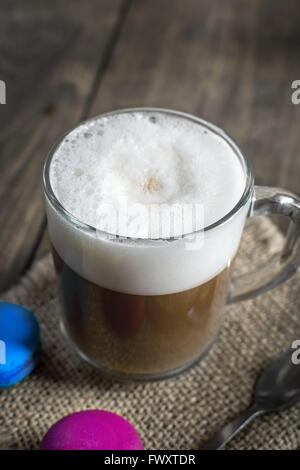 Cup of cappuccino and macaroons on table, close up Stock Photo