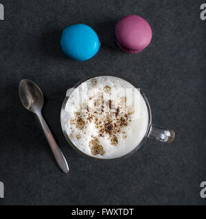 Cup of cappuccino and macaroons on table, top view Stock Photo