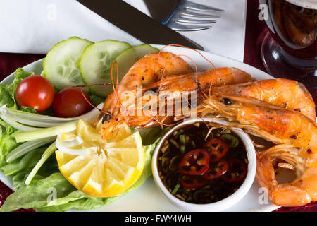 An English pub/bar dish of Sautéed King Prawns with Sweet Chili and Tamarind dip and a fresh side salad. Stock Photo