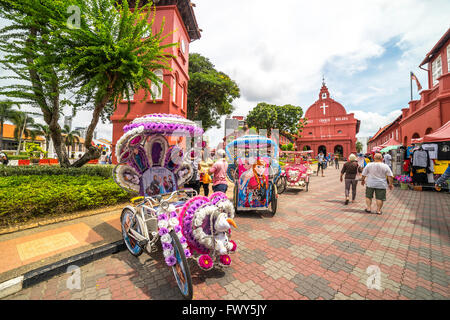 MALACCA, MALAYSIA - DEC 4, 2015: A row of trishaw in front of Christ Church & Dutch Square in Malacca City, Malaysia. It was bui Stock Photo