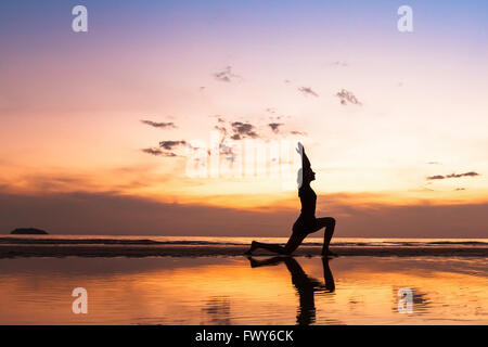 beautiful yoga exercise on the beach at sunset, background with copyspace Stock Photo