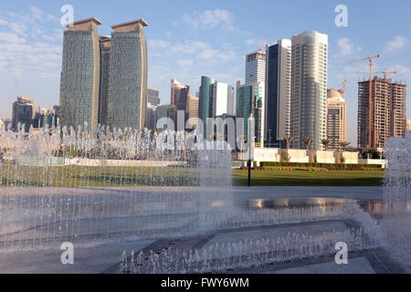 DOHA, QATAR - FEBRUARY 17, 2016: Skyscrapers in Doha business district seen behind newly installed fountains in Hotel Park, Stock Photo