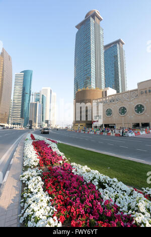 DOHA, QATAR - FEBRUARY 17, 2016: Municipal flowerbeds beside the City Centre mall and hotels in Dafna with labourers visible Stock Photo