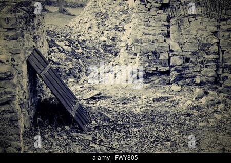 Wooden fence near by old dirty stone wall Stock Photo