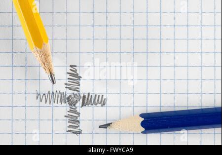 Blue and yellow pencil on white square paper. Stock Photo
