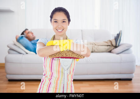 Composite image of smiling woman leaning on mop Stock Photo