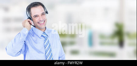 Composite image of smiling businessman using headset Stock Photo