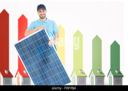 Composite image of smiling construction worker holding solar panel Stock Photo