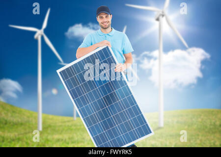 Composite image of smiling construction worker holding solar panel Stock Photo