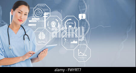 Composite image of surgeon using digital tablet with group around table in hospital Stock Photo