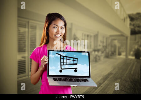 Composite image of smiling asian woman holding computer Stock Photo