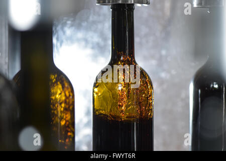 Wine bottle filling along conveyor belt in bottling factory Stock Photo