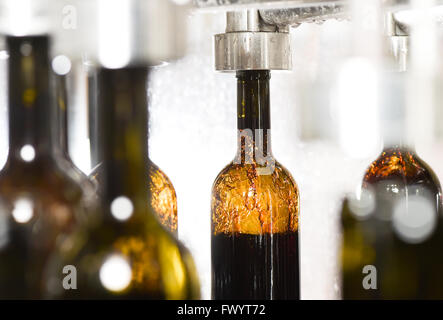 Wine bottle filling along conveyor belt in bottling factory Stock Photo