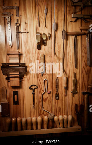 Many different old tools hanging on wall Stock Photo
