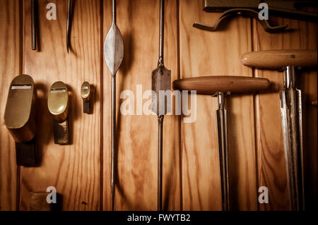 Many different old tools hanging on wall Stock Photo