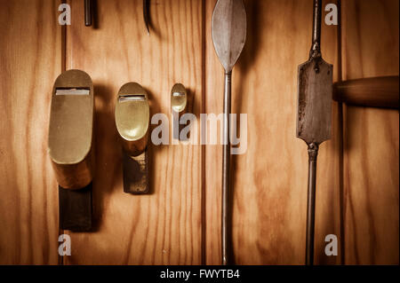 Many different old tools hanging on wall Stock Photo