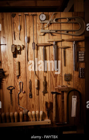 Many different old tools hanging on wall Stock Photo