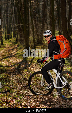 Mountain biker riding on bike in springforest landscape. Stock Photo