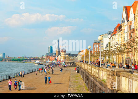 DUSSELDORF, GERMANY - MAY 3, 2013: Dusseldorf Rhine Embankmentr with tourists and St Lambertus Collegiate Church and Schiffahrtmuseum in the background. Stock Photo