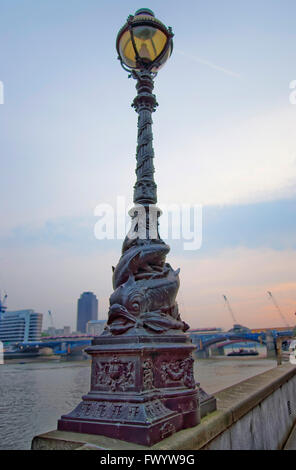 Dolphin lamp standard on Thames Embankment in London in England. The lamp has a decoration of two dolphins or sturgeons. Stock Photo