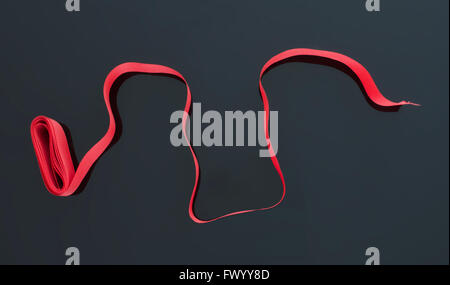 Curled red ribbon isolated on black background. Stock Photo