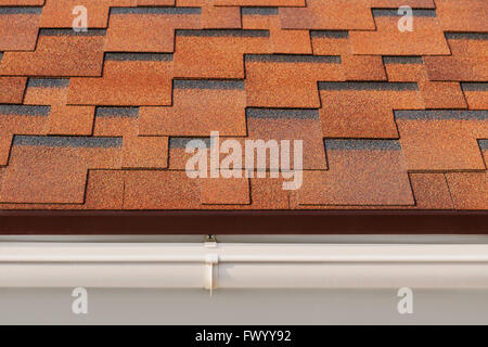 Bitumen asphalt shingles with plastic drainage on house roof. Stock Photo