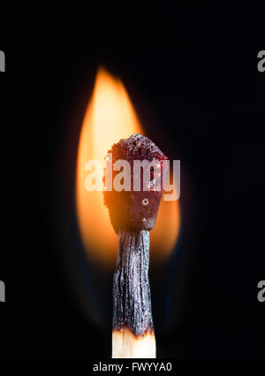 Burning match stick isolated on black backgorund. Stock Photo