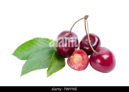 Three and one cut cherries next to leaves. Stock Photo