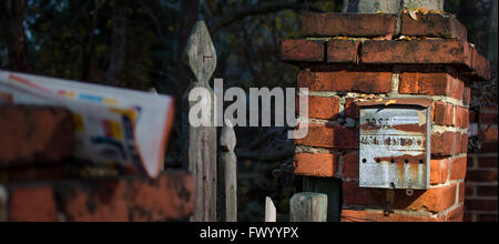 Very old rusty post box on the brick column. Stock Photo
