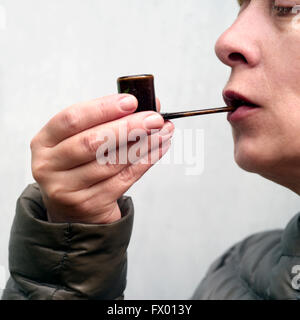 Middle aged female holding a smoking pipe Stock Photo